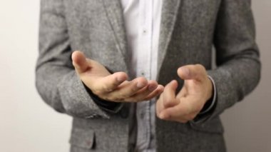 Gri ceketli ve benekli gömlekli beyaz arka planlı düz beyaz adam parmaklarında beş hızlı kadar sayma