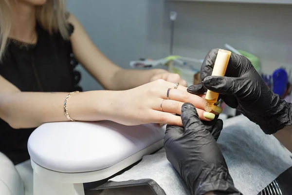 Gros plan sur le maître des ongles portant des gants noirs faisant des ongles acryliques dans le salon. Concept de visiter un institut de beauté — Photo