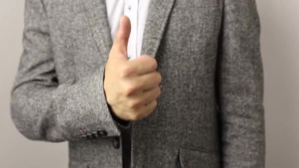 Homem caucasiano sólido em jaqueta cinza e camisa salpicada em fundo branco puxa aprovação polegar para cima. sinal de parabéns — Vídeo de Stock