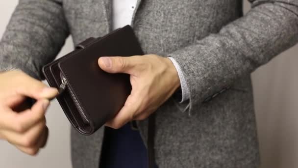 Hombre sólido con chaqueta gris sobre fondo blanco saca trescientos billetes de dólares de la billetera. Contando billetes de hombre — Vídeos de Stock