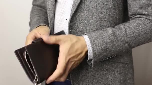 Hombre sólido con chaqueta gris sobre fondo blanco saca trescientos billetes de dólares de la billetera. Contando billetes de hombre — Vídeos de Stock