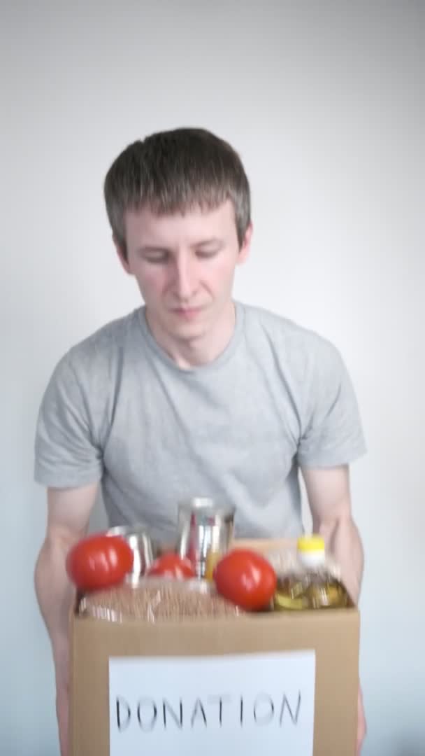 Courier worker delivers products, volunteer holds grocery food in donation box — Stock Video