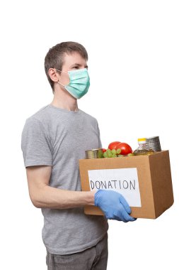 Sağlık maskesi, koruyucu eldivenler, karton bağış kutusunda sebze yağı, üzüm, teneke kutu, domates. Coronavirus yardım fonu, yardım, dağıtım, yerel destek