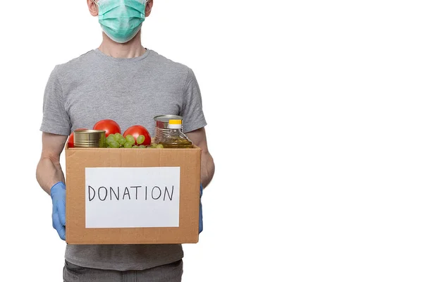 Sağlık maskesi, koruyucu eldivenler, karton bağış kutusunda sebze yağı, üzüm, teneke kutu, domates. Coronavirus yardım fonu, yardım, dağıtım, yerel destek