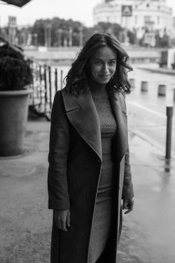 Siyah beyaz portre, gülümseyen, ceketli, balıkçı yakalı güzel bir kız. Çekici bir kadının sokak fotoğrafı, zarif bir modelin şehir fotoğrafı.