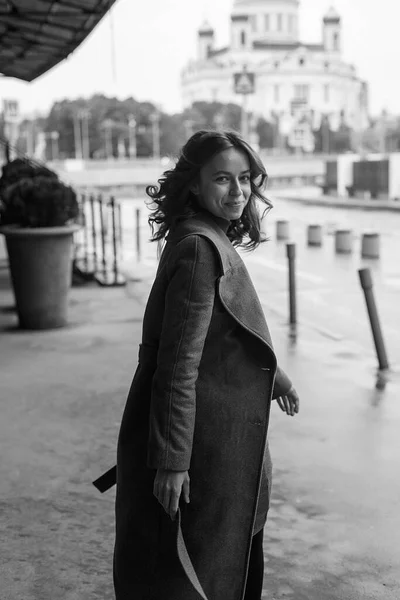 Siyah beyaz portre, gülümseyen, ceketli, balıkçı yakalı güzel bir kız. Çekici bir kadının sokak fotoğrafı, zarif bir modelin şehir fotoğrafı.