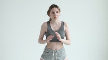 Genç fit kız aydınlık odada egzersiz yapıyor. Spor yapıyor, spor yapıyor.