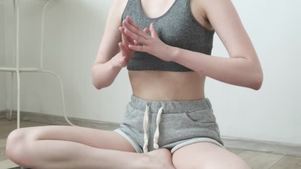 Menina bonita em sportswear sentado em pose de lótus, fazendo exercícios de ioga respiração — Vídeo de Stock