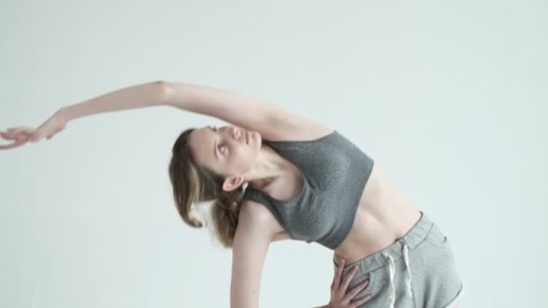 스 포오 츠 를 하는 젊은 운동 선수인 날씬 한 소녀는 몸을 기울이고 스트레칭을 한다 — 비디오