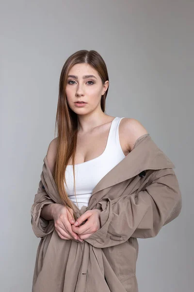 Caucasiana menina bonita em capa de chuva olha para a câmera. retrato de beleza, testes de modelo — Fotografia de Stock