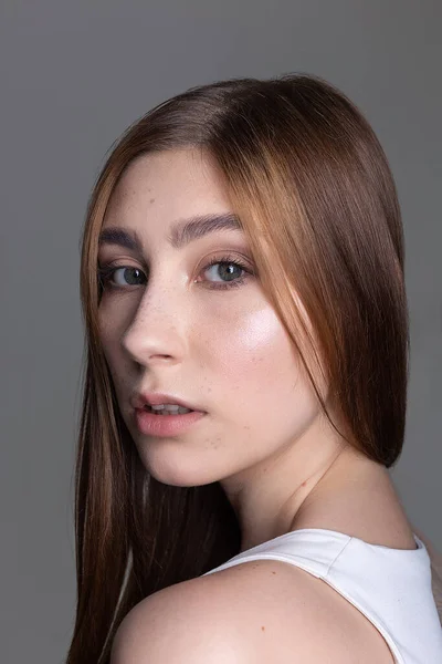 Kaukasiska tjejen med långt hår tittar på kameran. Skönhetsporträtt, modellprov — Stockfoto