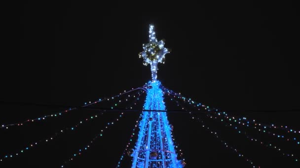 Albero di Natale artificiale. Luci ghirlanda lampeggiante sulla costruzione decorata — Video Stock