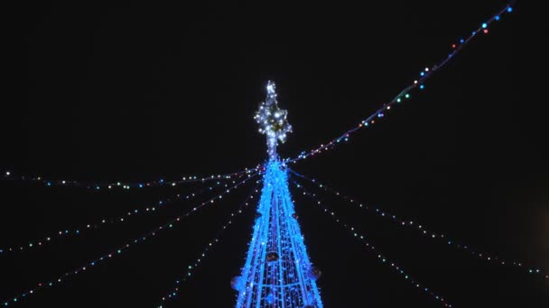 Albero di Natale artificiale. Luci ghirlanda lampeggiante sulla costruzione decorata — Video Stock