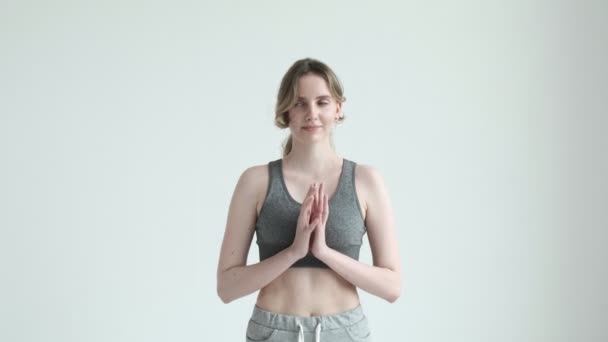 Glimlachend meisje in sportkleding, hand in hand met namaste gebaar. gezondheid levensstijl — Stockvideo