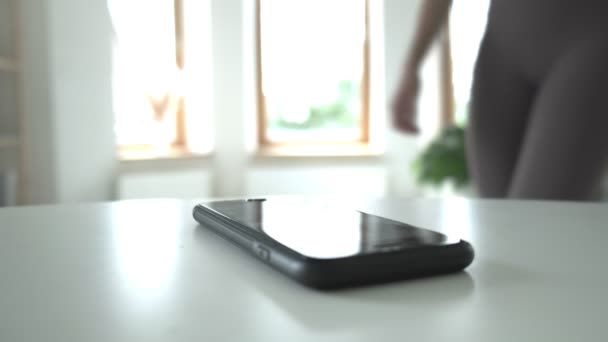 Jovem ajuste irreconhecível em leggings toca tela do smartphone, close-up — Vídeo de Stock