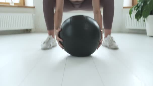 年轻的高加索黑发女子在家里提着沉重的球，健身锻炼 — 图库视频影像