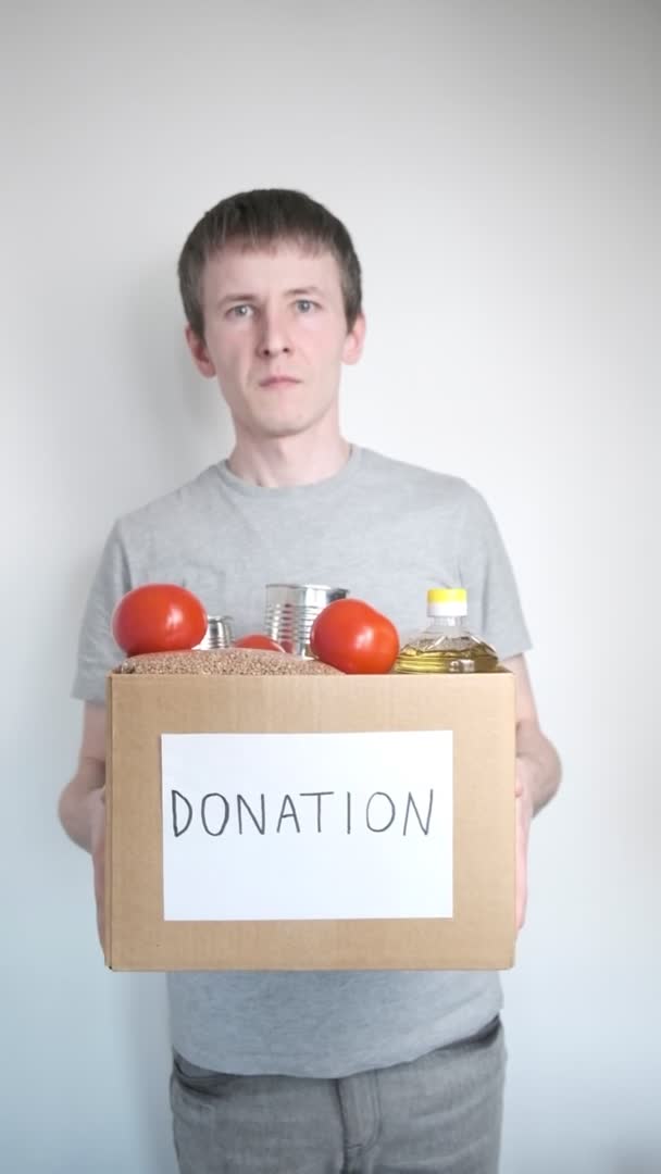 Courier worker delivers products, volunteer holds grocery food in donation box — Stock Video