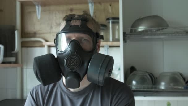 Man in gas mask sitting at kitchen at home. chemical weapon, virus protection — Stock Video