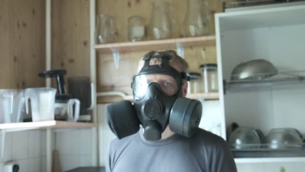 Man in gas mask sitting at kitchen at home. chemical weapon, virus protection — Stock Video