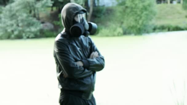 Hombre con máscara de gas cerca del depósito tóxico. protección de armas químicas, epidemia de virus — Vídeo de stock