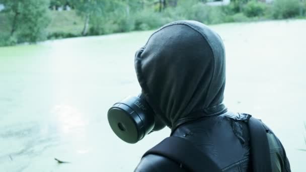 독극물 저 장소 근처에서 가스 마스크를 쓰고 있는 남자. 화학 무기 보호, 바이러스 유행병 — 비디오