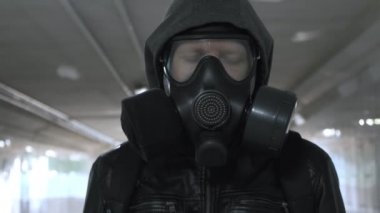 Gaz maskeli adam, kapüşonlu siyah ceket uzun tünelden geçiyor, alt geçit.