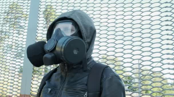 Людина в газовій масці під час епідемії, що стоїть на відкритому повітрі. хімічна зброя, захист від вірусів — стокове відео