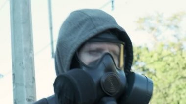 Dışarıda yürüyen gaz maskeli bir adam. Kimyasal silah, virüs koruması