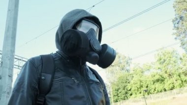 Dışarıda yürüyen gaz maskeli bir adam. Kimyasal silah, virüs koruması