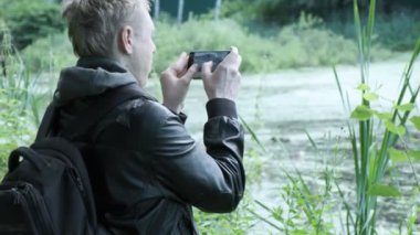 Adam akıllı telefonlu ördeklerin fotoğraflarını çekiyor. Kuşların vahşi yaşam fotoğraflarını çekmek