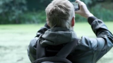 Adam akıllı telefonlu ördeklerin fotoğraflarını çekiyor. Kuşların vahşi yaşam fotoğraflarını çekmek
