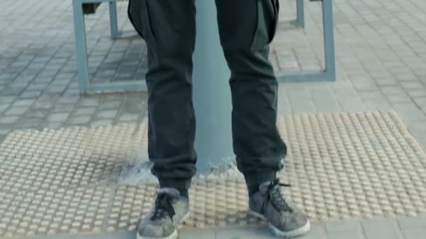 Mężczyzna w masce gazowej w kurtce z kapturem i plecakiem stojący na peronie kolejowym — Wideo stockowe