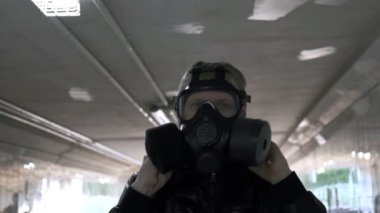 Adam yüzüne gaz maskesi takar, kapüşon takar ve uzun tünellerde yürür.