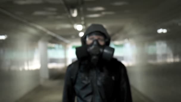 头戴防毒面具的男子,黑色夹克,头罩立在长隧道中,地下通道 — 图库视频影像