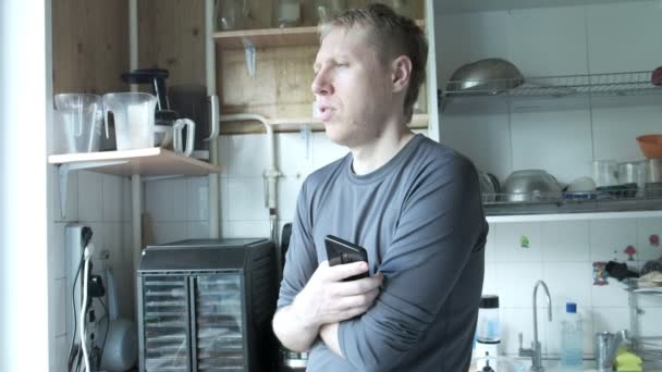 Omtänksam kaukasisk man står vid gamla sovjetiska köket, talar för sig själv — Stockvideo
