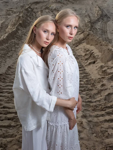Zwei attraktive Zwillingsschwestern posieren in eleganter weißer Kleidung am Sandsteinbruch — Stockfoto