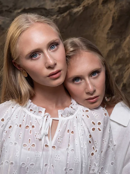 Dois jovens loiros muito gêmeos posando na pedreira de areia em roupas brancas elegantes — Fotografia de Stock