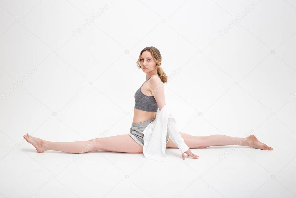 pretty girl practice yoga, doing splits, stretching exercise on white background