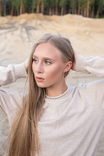 Atractiva chica caucásica con el pelo largo y maquillaje desnudo posando al aire libre en la arena — Foto de Stock