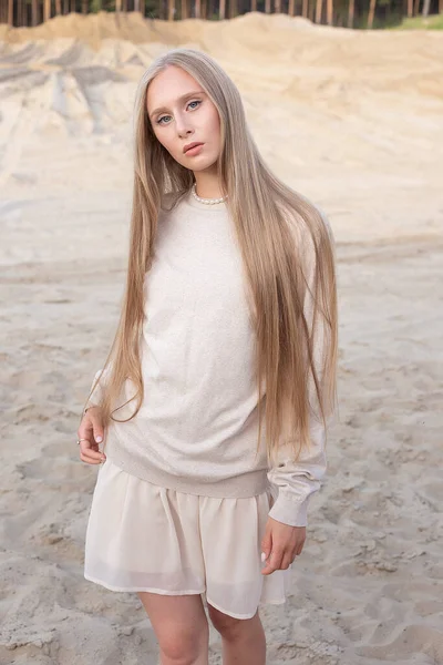 Attractive caucasian girl with long hair and nude makeup posing outdoors on sand — Stock Photo, Image