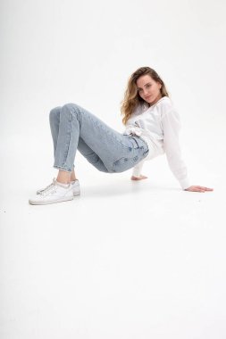 Genç beyaz kız yerde yatıyor, vücudunu kaldırıyor, siklonamada geriniyor.