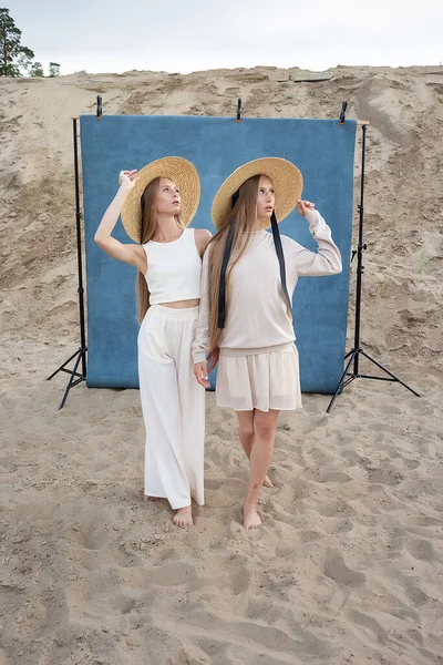 Portrait de beauté en plein air sur sable devant fond bleu, jeunes jolis jumeaux — Photo