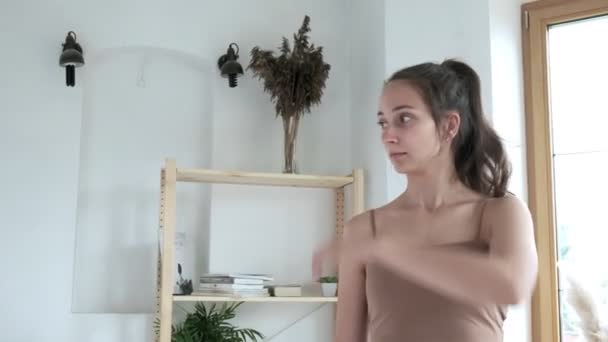 Trött ung kaukasisk flicka torkar svett från pannan efter effektiv träning — Stockvideo