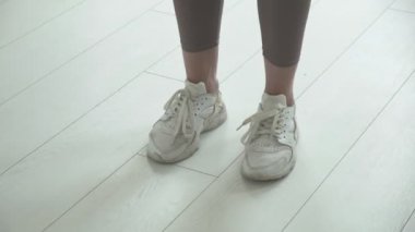 Spor ayakkabılı kadın ayaklarının yakın çekimi ip atlarken havada zıplıyor.