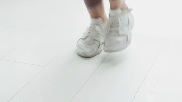 Primer plano de los pies femeninos en zapatillas de deporte saltando en el aire mientras se utiliza saltar la cuerda — Vídeos de Stock