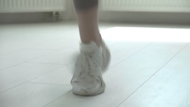 Крупним планом жіночі ноги в кросівках стрибають в повітрі під час використання пропускаючої мотузки — стокове відео