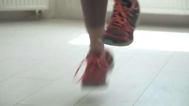 Närbild av kvinnliga fötter i sneakers hoppar i luften när du använder hopprep — Stockvideo