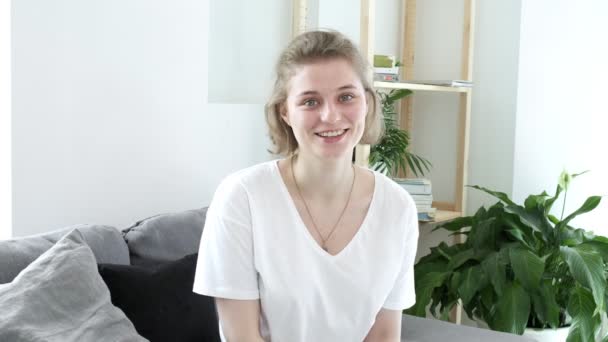 Happy female blogger sits on sofa, speaks to webcam. video conference call — Stock Video
