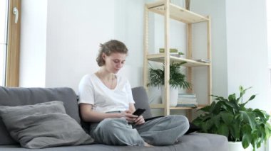 Kız akıllı telefon kullanarak sosyal medyada geziniyor, haberleri kontrol ediyor, mesajlar yolluyor.