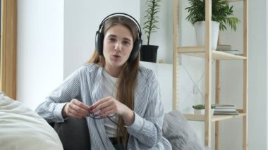 Mutlu kadın blogcu kanepeye oturur, webcam ile konuşur, video konferans görüşmesi yapar.